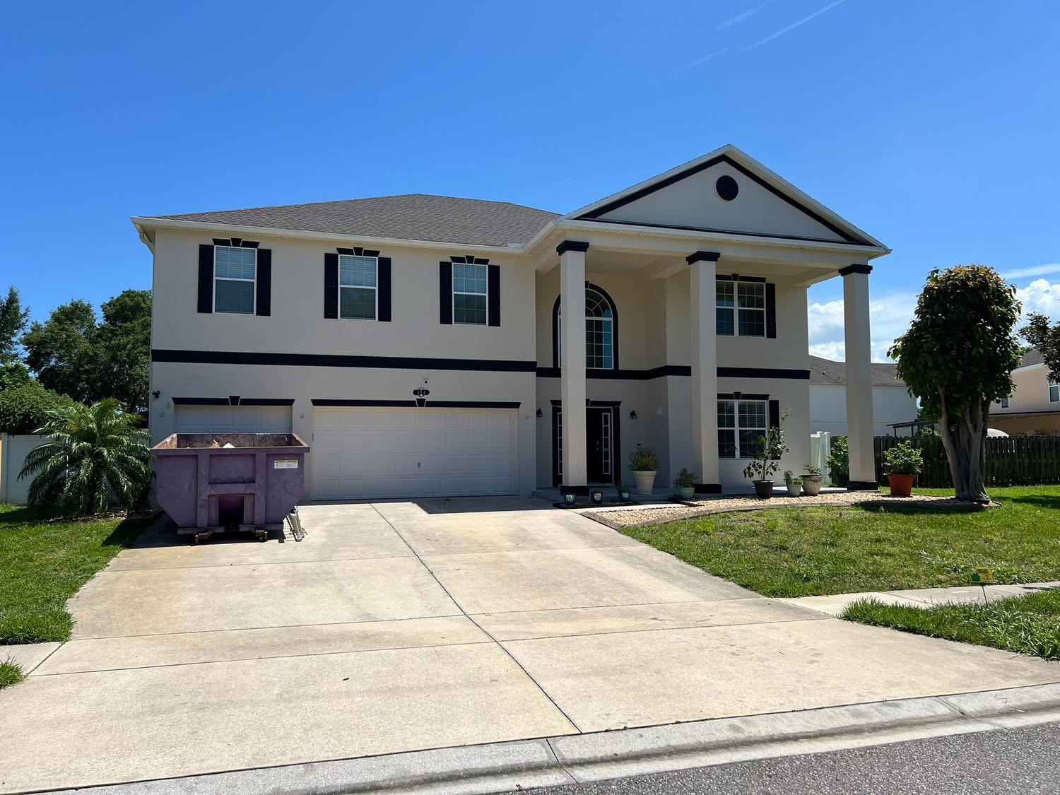 Same home with finished cream siding and dark accent trim