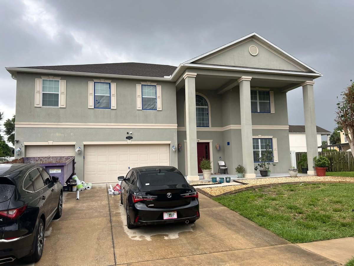 Large two-story home during prep before exterior painting